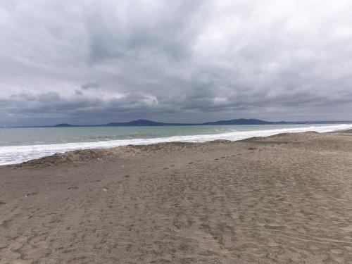 a sandy beach with the ocean on a cloudy day at Mirana Family Hotel in Burgas City