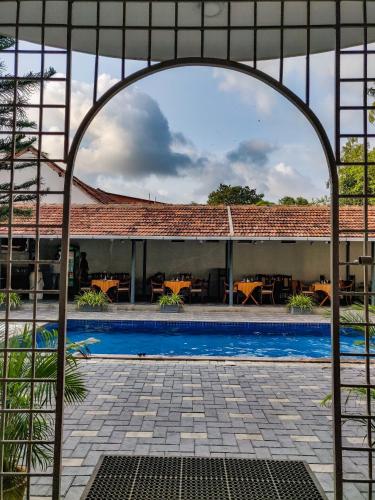 an archway over a swimming pool with a building at Dutch Bungalow in Cochin
