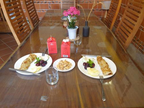 trois plaques alimentaires sur une table en bois dans l'établissement Mount Taiwu Cozy B&B, à Jinhu