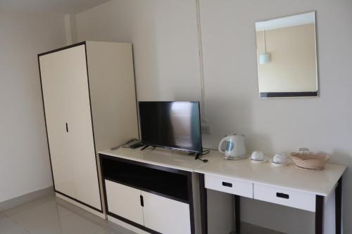 a room with a desk with a tv and a mirror at Ladapan Mansion in Nonthaburi