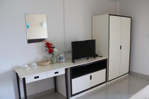 Habitación con escritorio y TV. en Ladapan Mansion, en Nonthaburi