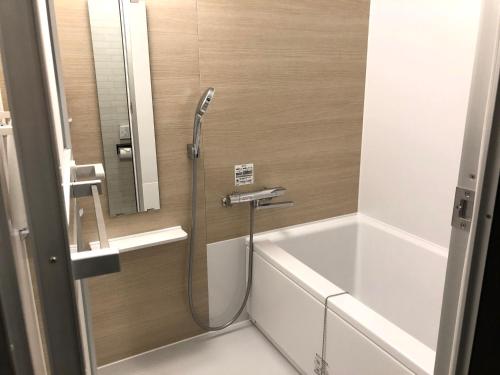 La salle de bains est pourvue d'une douche, d'une baignoire et d'un lavabo. dans l'établissement Hotel Sun Road, à Amakusa