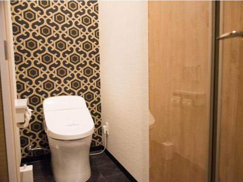 a small bathroom with a toilet and a shower at Hotel Sun Road in Amakusa