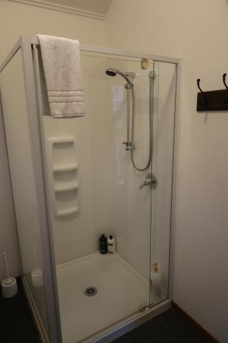 a bathroom with a shower with a glass door at The Tinkers Cottage in Clyde