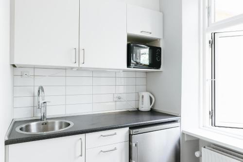 a kitchen with a microwave and a sink at City Hotel Nebo in Copenhagen