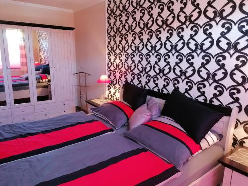 - une chambre dotée d'un lit avec une couverture noire et rouge dans l'établissement Lagunenstadt Ueckermünde, à Ueckermünde