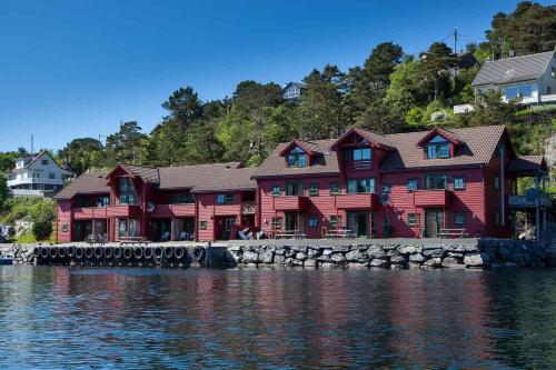 a large red house sitting next to the water at Florø Rorbu in Florø