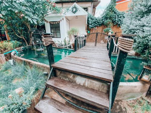 a wooden boardwalk leading to a house with a pool at The Castello Resort in Ko Larn