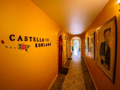 a hallway with a yellow wall with a sign on it at The Castello Resort in Ko Larn