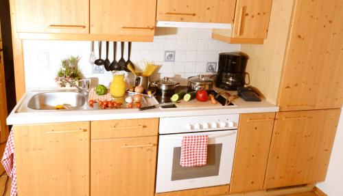 La cuisine est équipée de placards en bois et d'une cuisinière blanche. dans l'établissement Hüttstädterhof Familie Pötsch, à Aigen im Ennstal