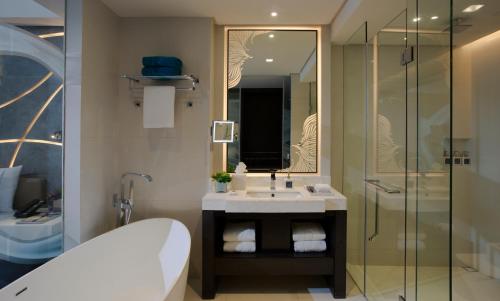 y baño con bañera, lavamanos y ducha. en The Lind Boracay en Boracay