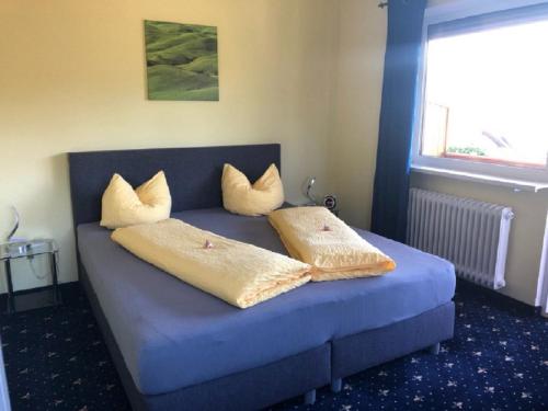 a bed with two pillows on it in a room at Pension Elan in Bayerisch Eisenstein