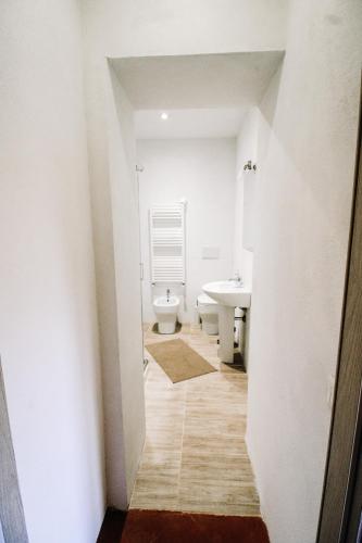 a white bathroom with a toilet and a sink at Villa Lilia by Let in Siena