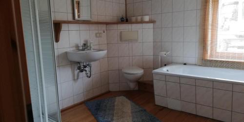 a bathroom with a tub and a sink and a toilet at Herberge an den Gärten in Lauchröden
