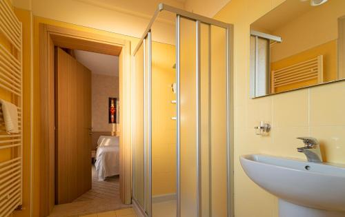 a bathroom with a glass shower and a sink at Hotel Mirandola in Mirandola