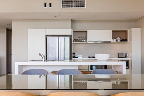 a kitchen with a glass table and chairs at Smiths Beach Resort in Yallingup
