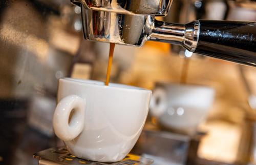 a coffee being poured into a coffee cup at Hotel Mirandola in Mirandola
