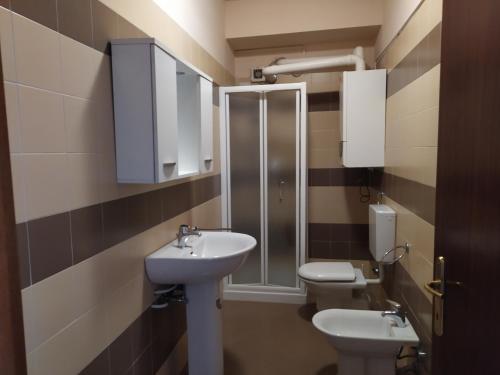 La salle de bains est pourvue de 2 toilettes, d'un lavabo et d'une douche. dans l'établissement Appartamento in centro a Poviglio (Re), à Poviglio