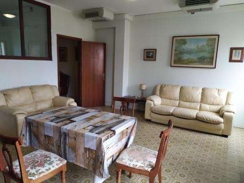 - un salon avec une table et des chaises en bois dans l'établissement Appartamento in centro a Poviglio (Re), à Poviglio