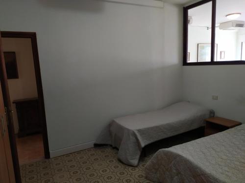1 Schlafzimmer mit 2 Betten und einem Fenster in der Unterkunft Appartamento in centro a Poviglio (Re) in Poviglio