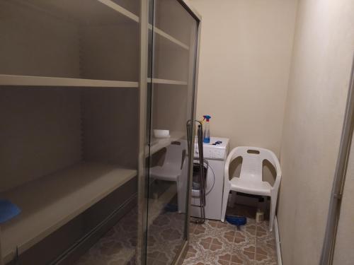 une petite salle de bains avec une cabine de douche en verre et une chaise dans l'établissement Appartamento in centro a Poviglio (Re), à Poviglio