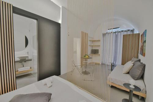 una camera da letto con specchio, letto e lavandino di Voltabianca Suite a Ostuni
