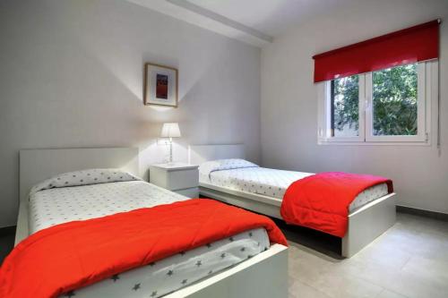 カラ・フィゲラにあるNa Pallissera 2の白い部屋のベッド2台 赤いシーツ付