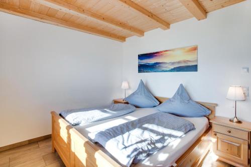a bedroom with a bed with blue pillows at Ferienwohnung Seeblick in Bad Heilbrunn