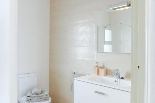a white bathroom with a sink and a toilet at La Lujancita in Puerto del Carmen