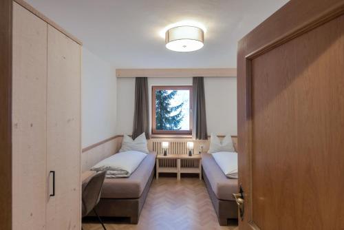 Cette petite chambre comprend un lit et une fenêtre. dans l'établissement Apt Emil - Haus Kostner, à Santa Cristina Valgardena