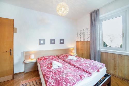 a bedroom with a large bed with a pink blanket at Villa Pineta in Moena