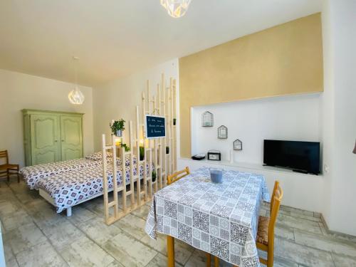 a dining room with a table and a tv at La Chtite Maison Béarnaise in Arthez-de-Béarn