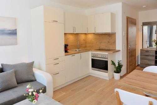 cocina y sala de estar con sofá y mesa en Apartment Blaser, en Mühlbachl