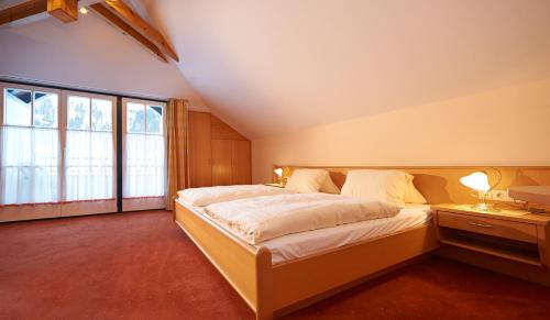 een slaapkamer met een groot bed en een groot raam bij Gästehaus Emmi in Kleinarl