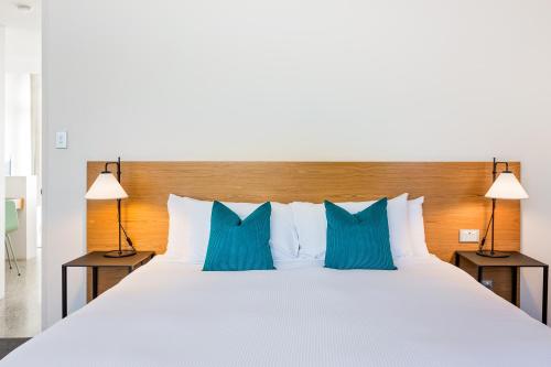 a bedroom with a large bed with blue pillows at Smiths Beach Resort in Yallingup
