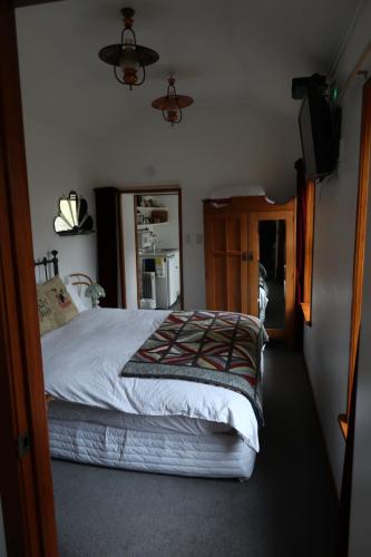 a bedroom with a bed and a television in it at The Tinkers Cottage in Clyde