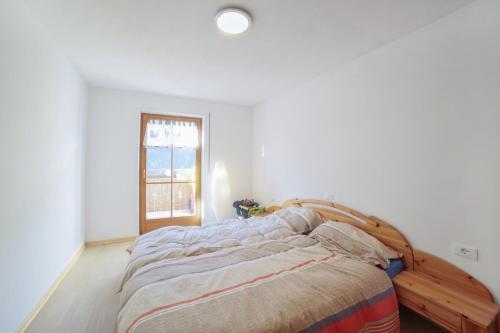een slaapkamer met een bed met een houten frame en een raam bij Strickerhof - Appartment 3 in Saltusio
