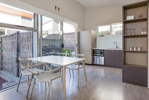 a kitchen with a table and chairs and a refrigerator at Smiths Beach Resort in Yallingup