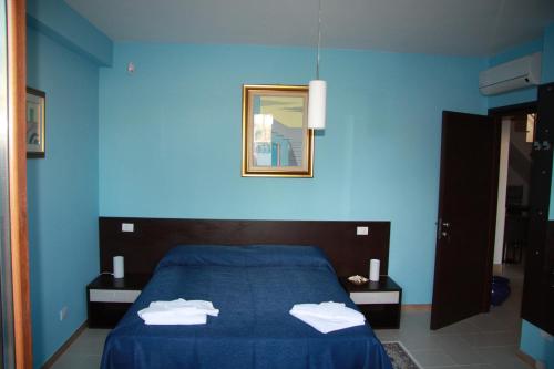 Dormitorio azul con cama y espejo en B&B Angolo Felice, en Matera