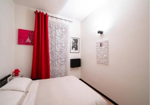 - une chambre avec 2 lits et un rideau rouge dans l'établissement BnButler - Navigli Apartment - Vicolo Lavandai, à Milan
