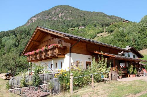 una casa en las montañas con flores en el balcón en Verleierhof, en Castelrotto