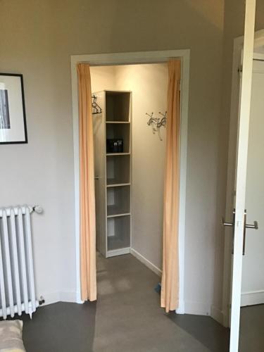 un couloir avec une porte ouverte sur une pièce avec une étagère dans l'établissement Le Clos Doménat 2, à Brive-la-Gaillarde