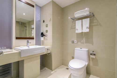 a bathroom with a white toilet and a sink at Sanya Sun and Sea Gueshouse in Sanya