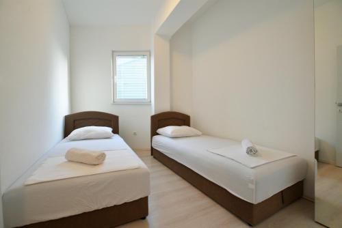 two beds in a room with a mirror at Apartman Lunga, Murter in Murter
