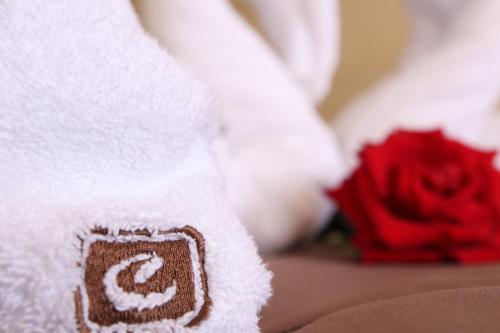 a towel with the letter c on it next to a red rose at Casablanca Hotel - All Inclusive in Obzor