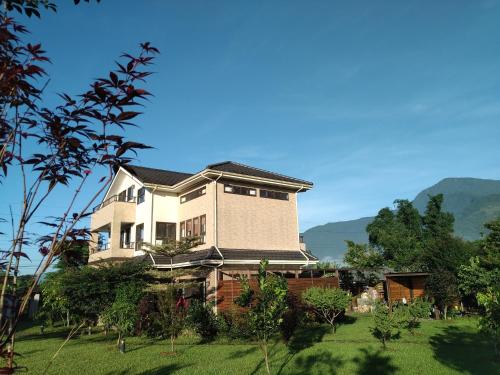 uma casa grande em cima de um jardim verde em Celine's B&B em Fenglin