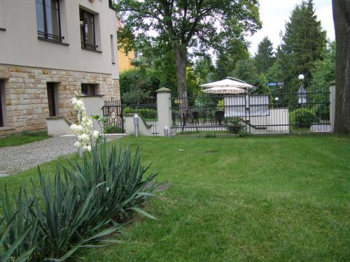 a yard with a fence and an umbrella at Jasny Dwór in Polanica-Zdrój