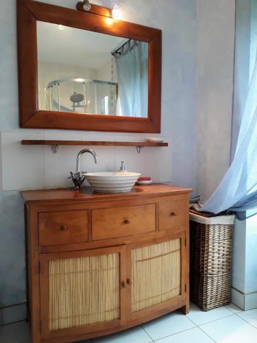 a bathroom with a sink and a mirror on a dresser at le gite du jardinier in Saint-Martin-lʼAiguillon