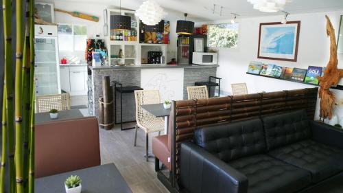 une salle d'attente avec un canapé et une table dans l'établissement Ohana Lodge, à Moliets-et-Maa