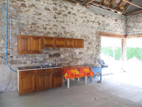 a kitchen with a sink and a stone wall at Le 128, duplex alsacien 10 personnes, piscine in Horbourg